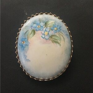 Hand painted porcelain brooch in brass frame with blue flowers